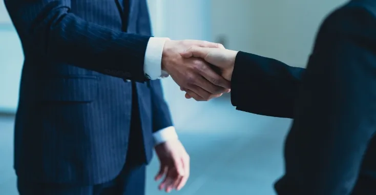 固い握手をするビジネスパートナー